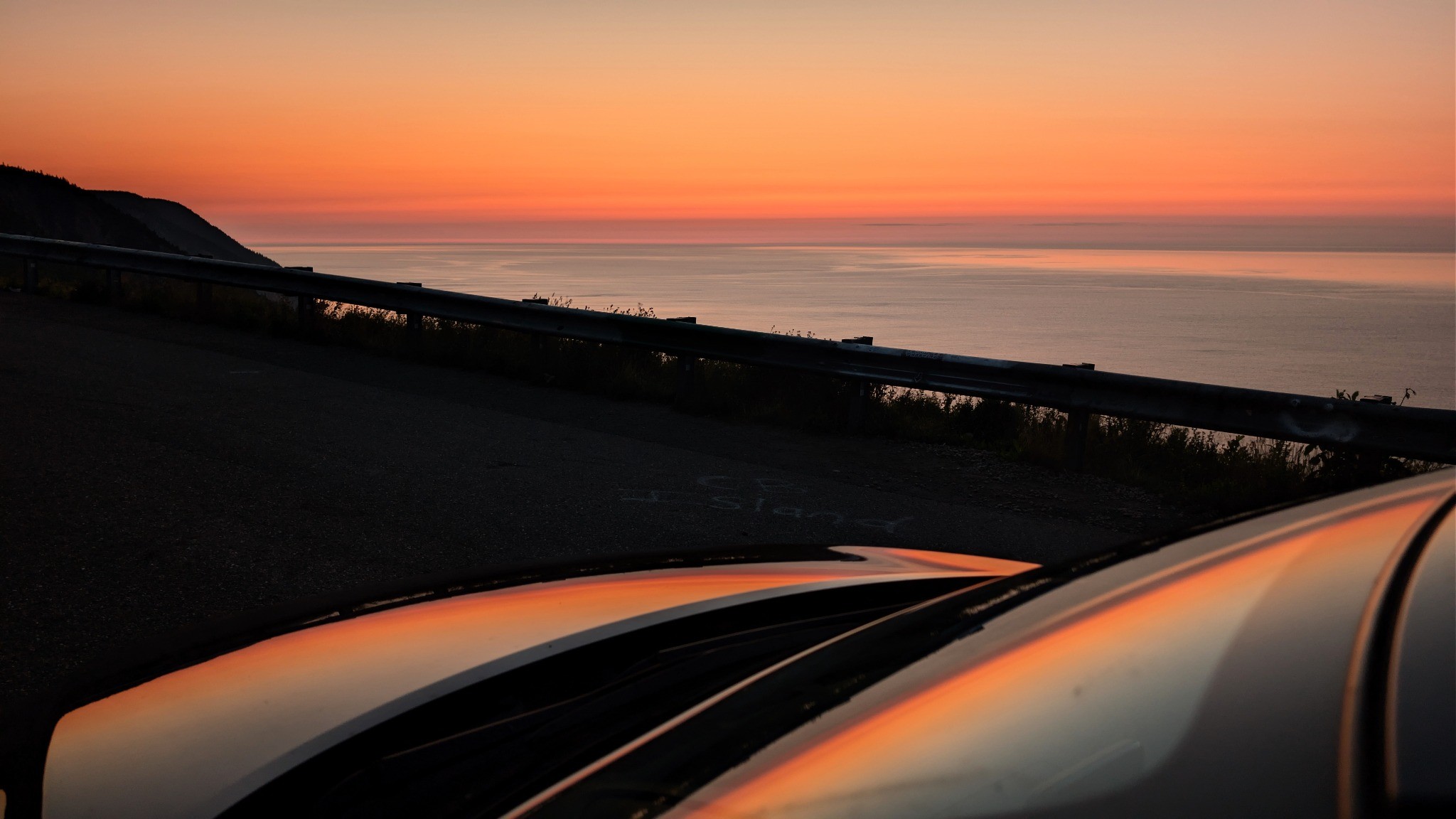 Sunset reflected on a car beside the coast