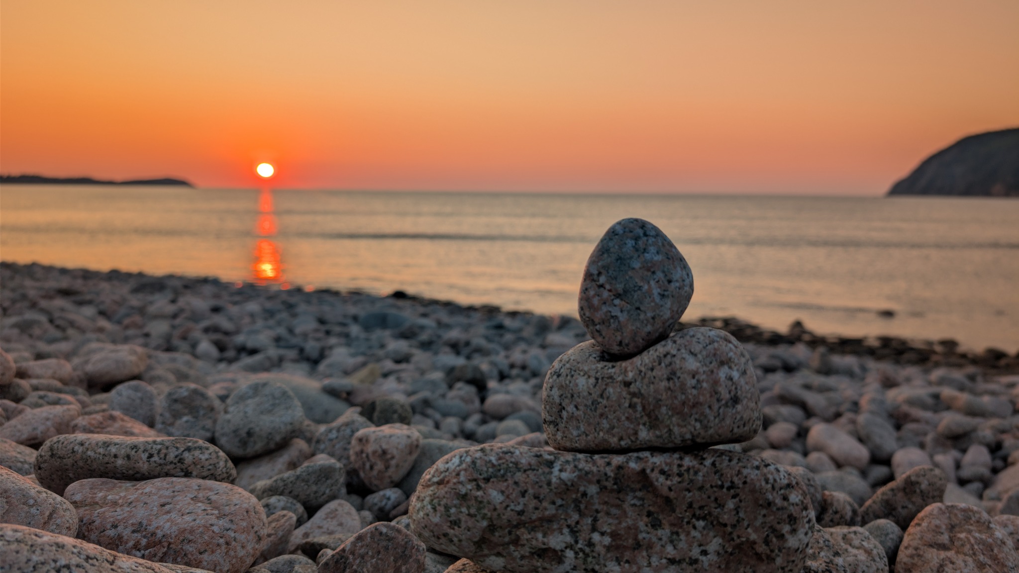 Balanced stones on a rocky beach at sunset in Cape Breton